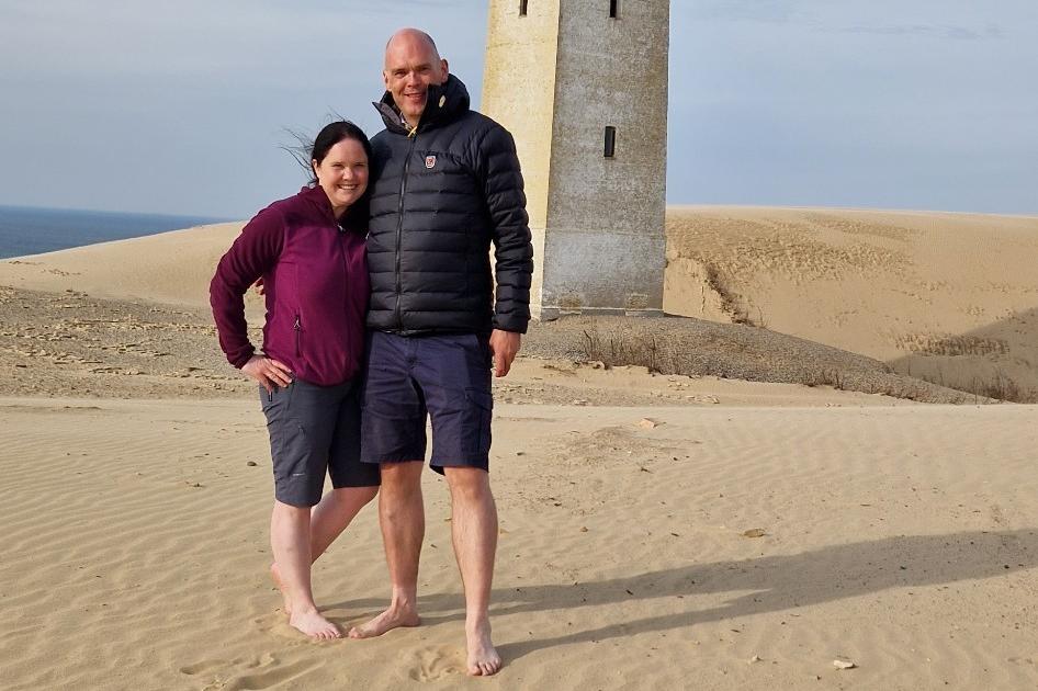 Mann og kone som poserer i sand.