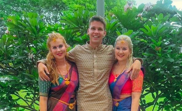 En mann og to kvinner i indisk klesdrakt 