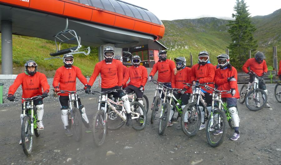 Studenter på sykkeltur i alpinanlegg.