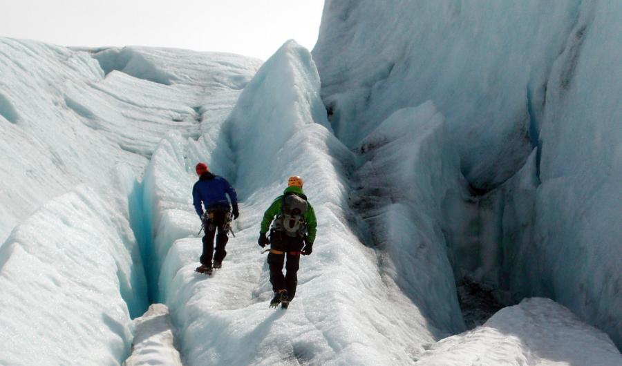 To personer som går på en isbre.