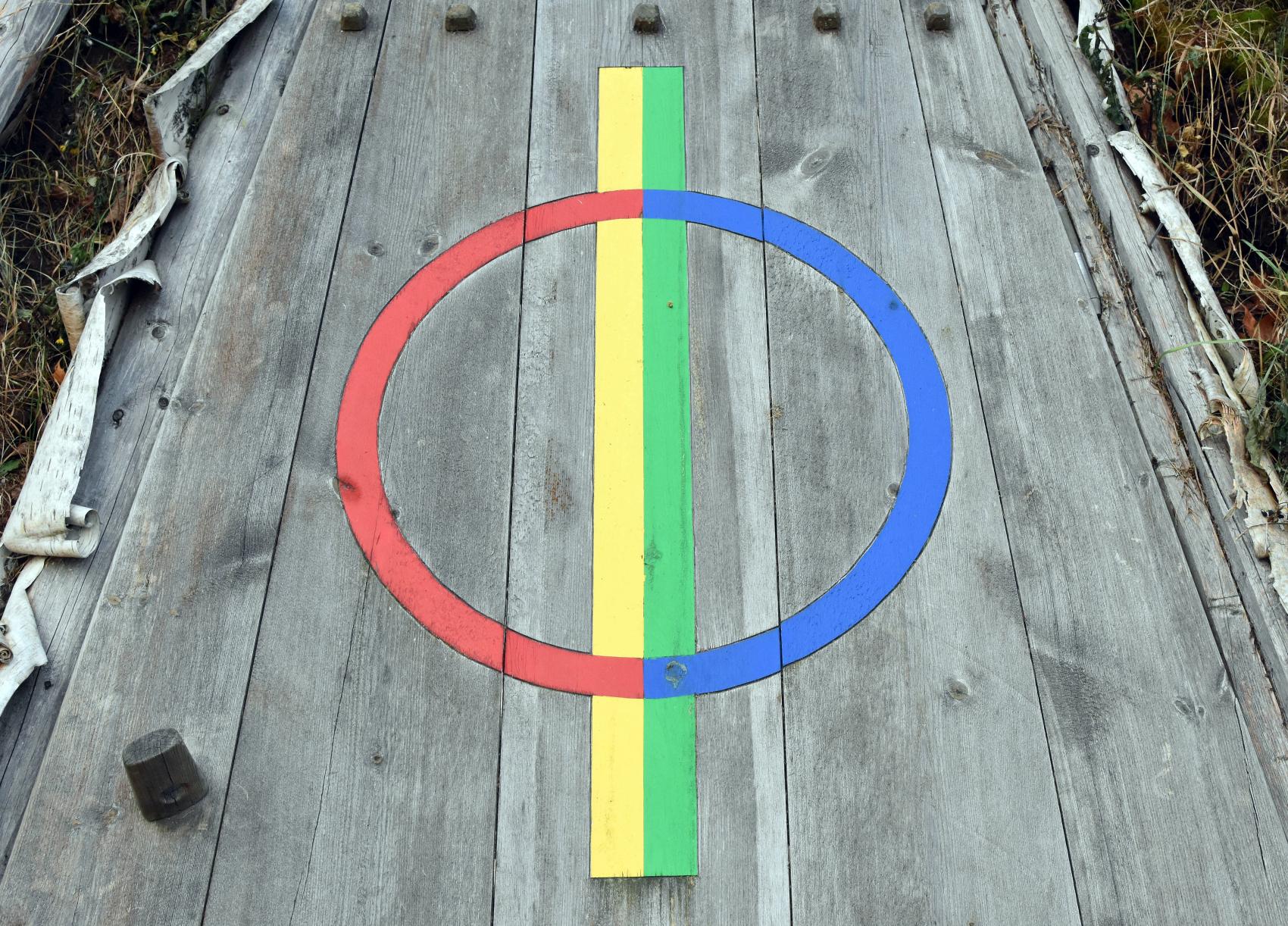 Bilde av et fargerikt, samisk symbol på ei gammedør.