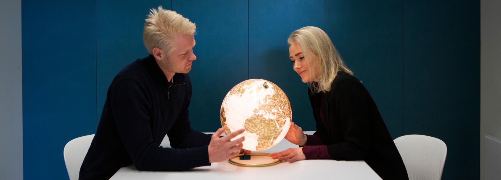 To studenter ser på en lysende globus
