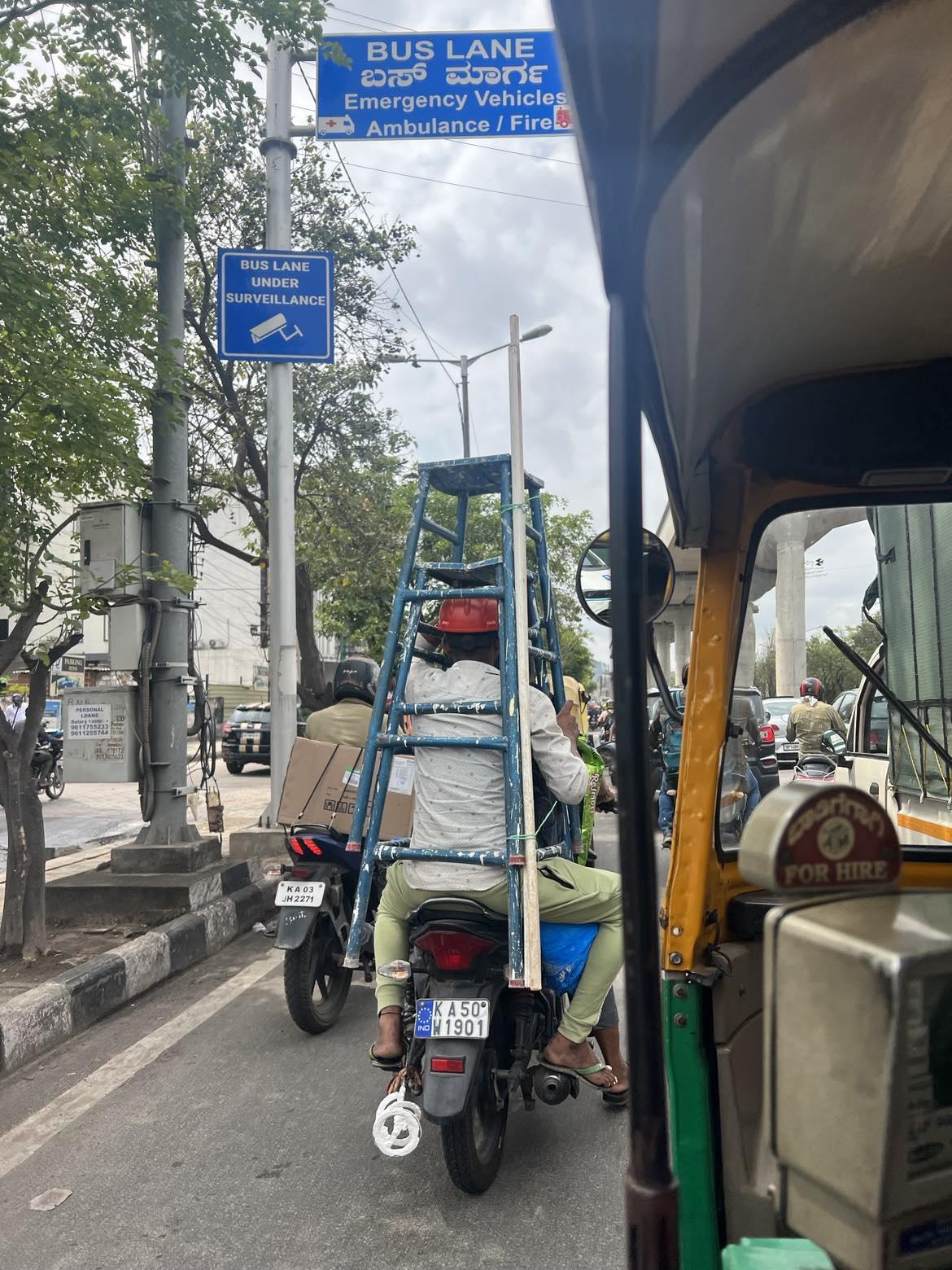 To menn på moped i ei tong gate i India
